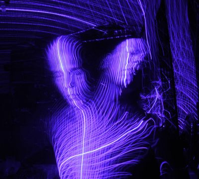 a woman is dancing in a purple light