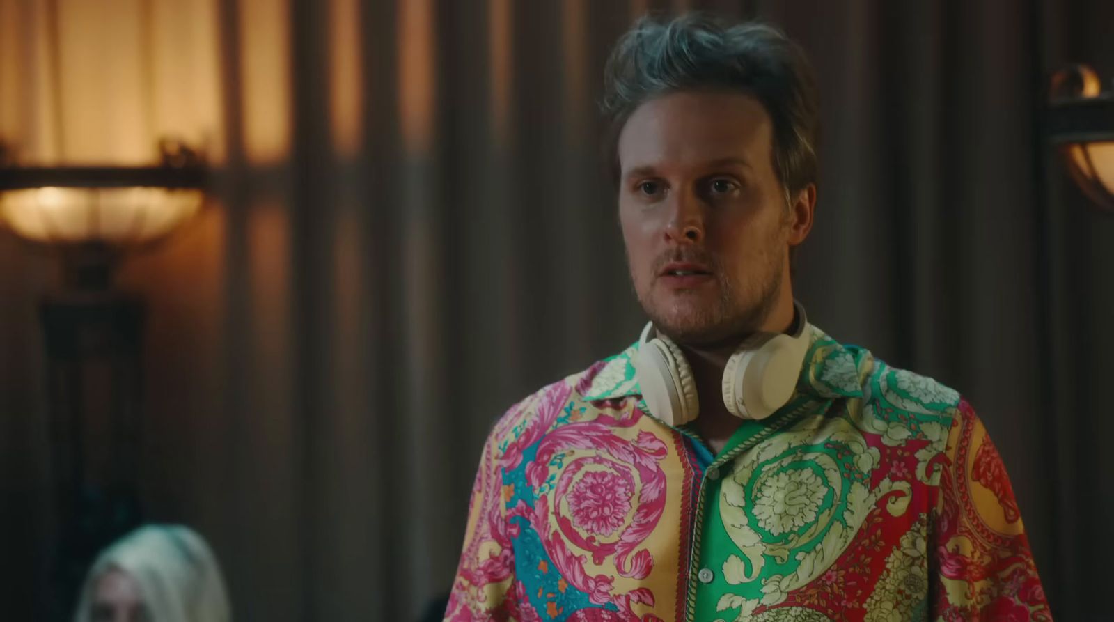 a man in a colorful shirt standing in a room