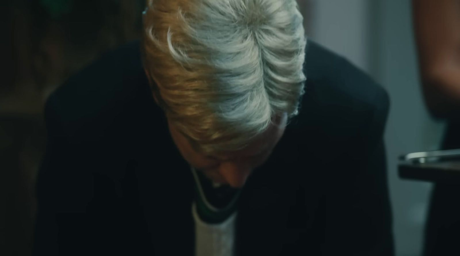 a woman with white hair is looking at a cell phone