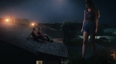 a couple of women sitting on top of a roof