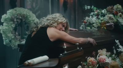 a woman sitting at a table with flowers on it