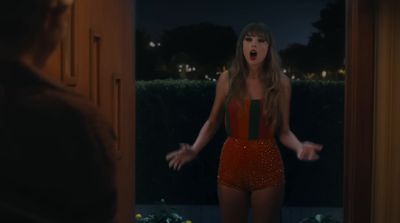 a woman in a red bodysuit standing in a doorway