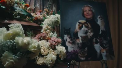 a picture of a woman with cats and flowers