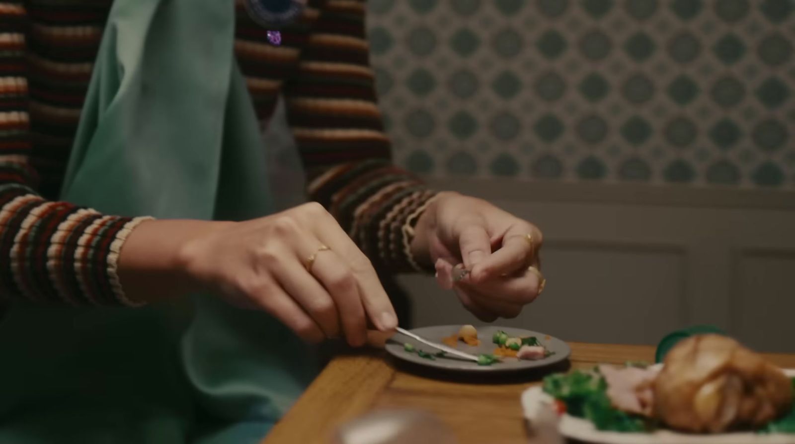 a woman in a striped shirt is eating a plate of food