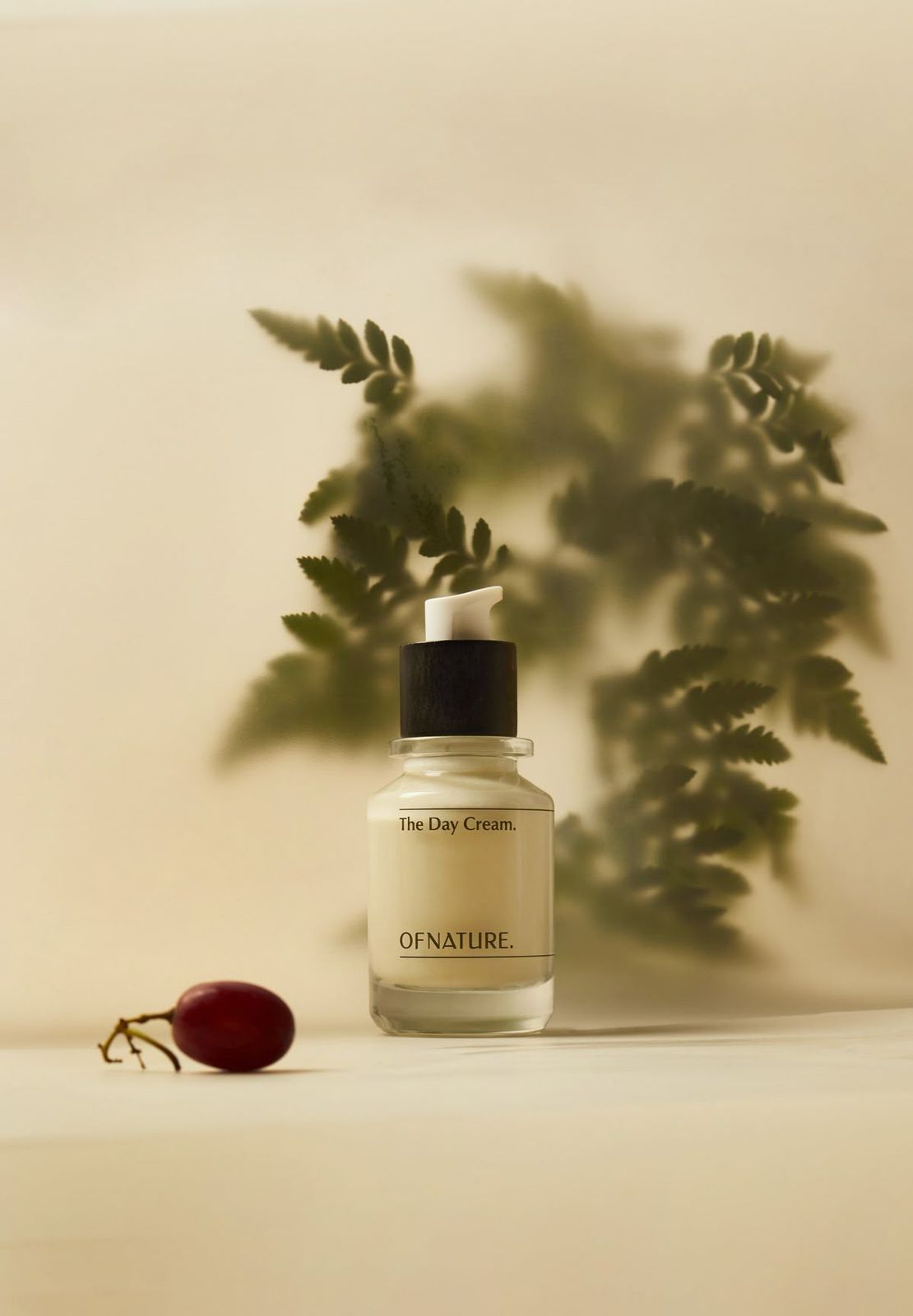 a bottle of oil sitting next to a cherry