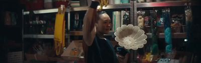 a man holding a fan in a room full of books
