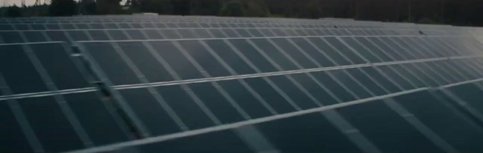 a large solar panel with trees in the background