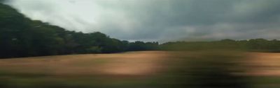 a blurry picture of a field with trees in the background