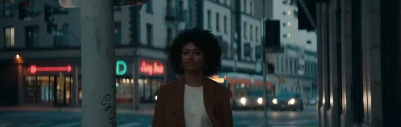 a woman standing on a city street at night