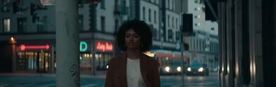 a woman standing on a city street at night