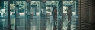 a couple of people standing in front of a glass wall