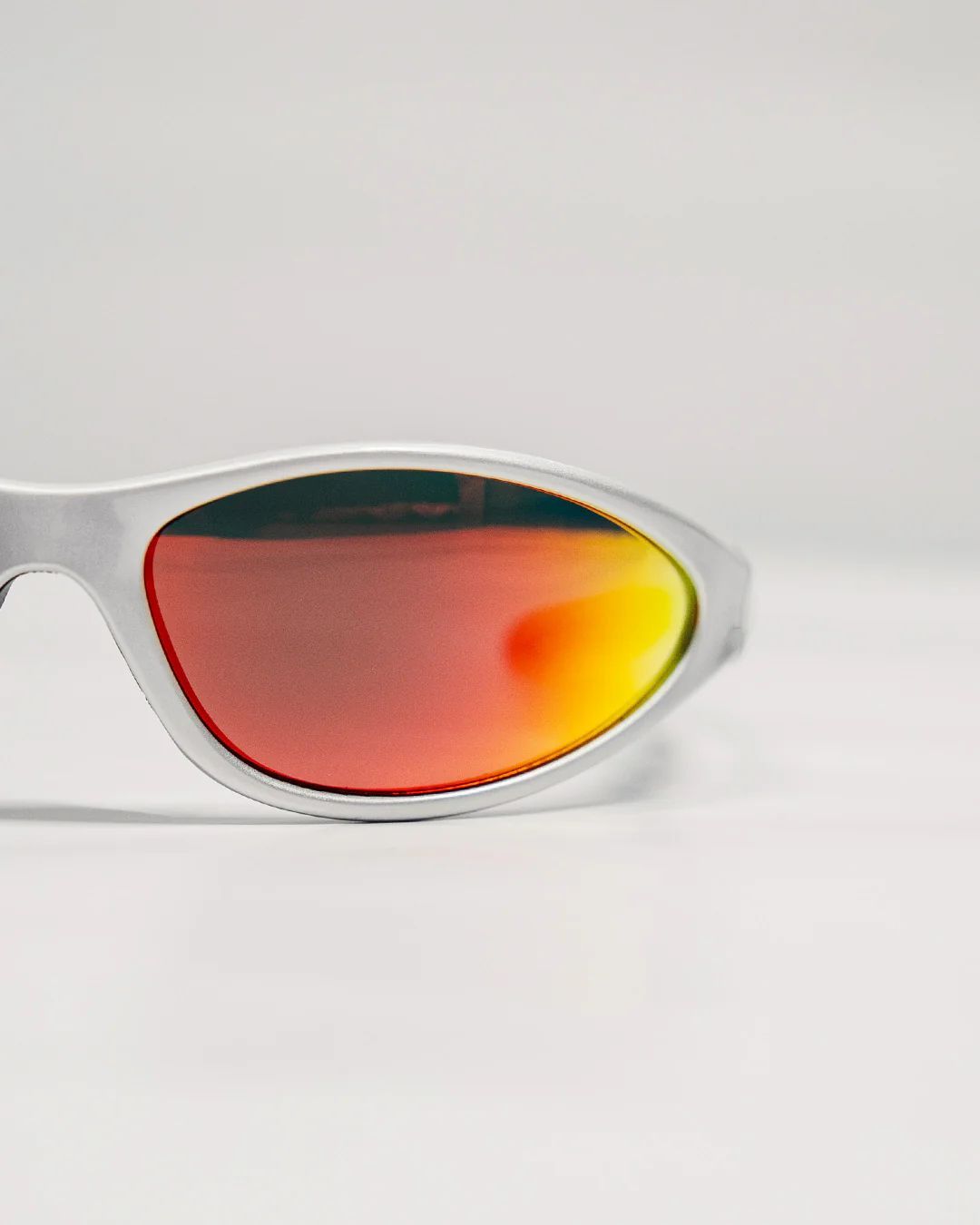 a pair of white sunglasses with red mirrored lenses