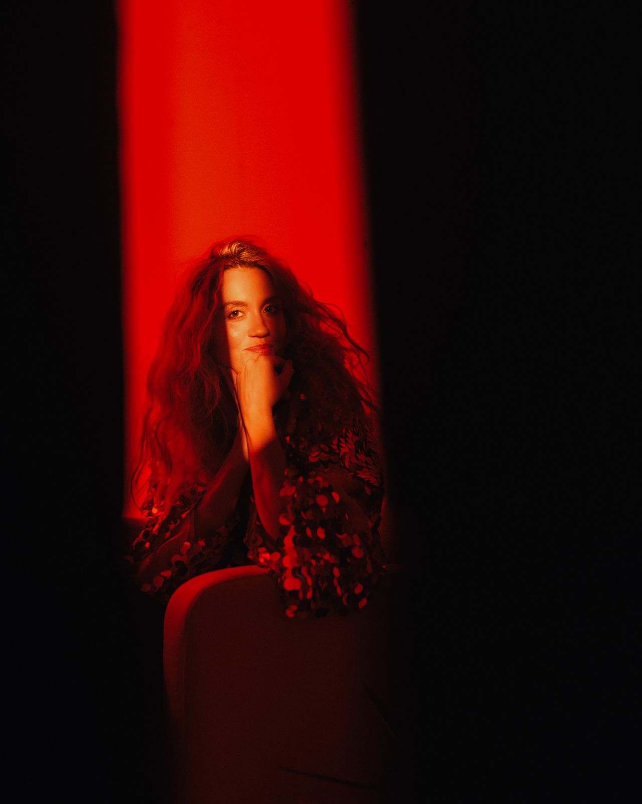 a woman sitting in a chair with her hand on her face