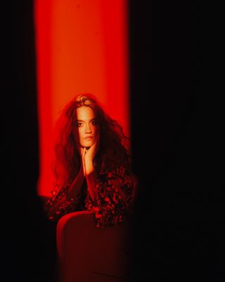 a woman sitting in a chair in a dark room