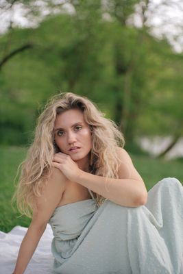 a woman in a dress sitting on a blanket