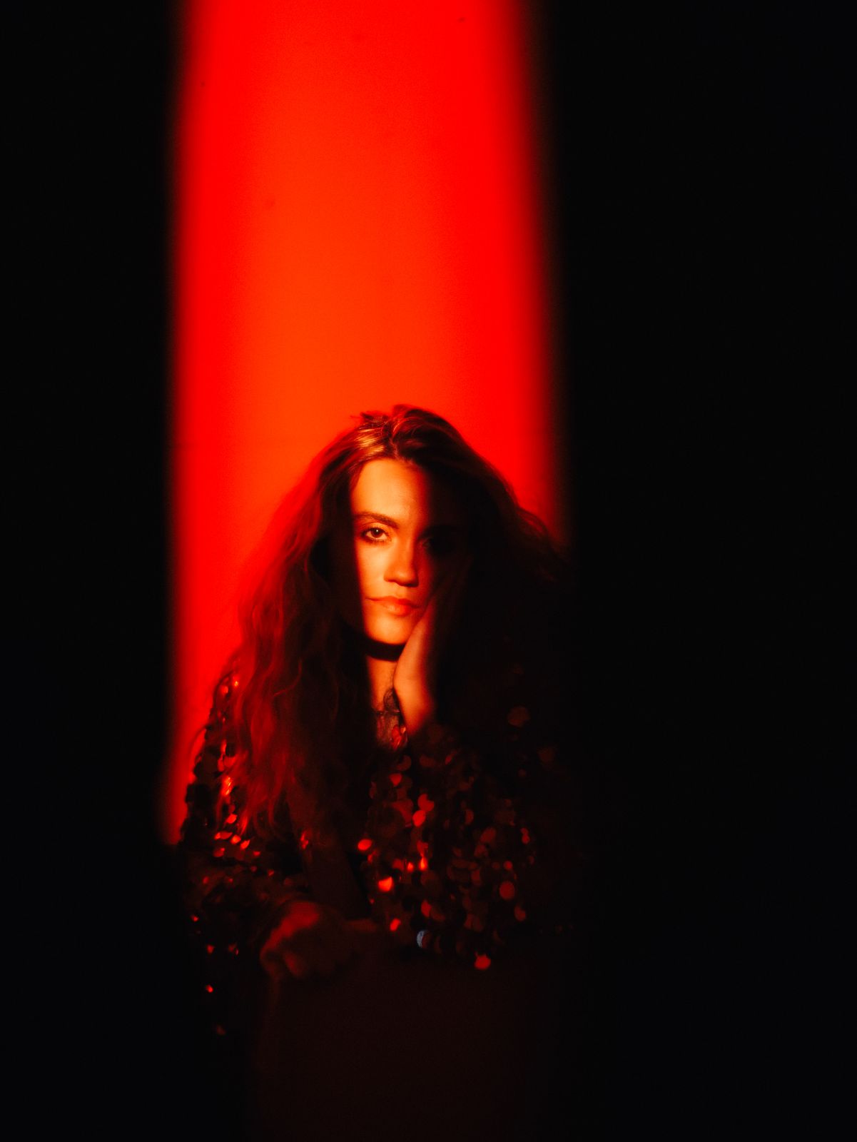 a woman standing in front of a red light