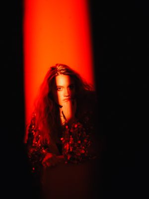 a woman sitting in a chair with a red light behind her