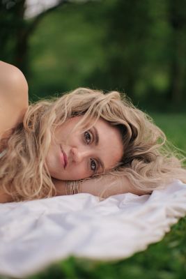 a woman laying on a blanket in the grass