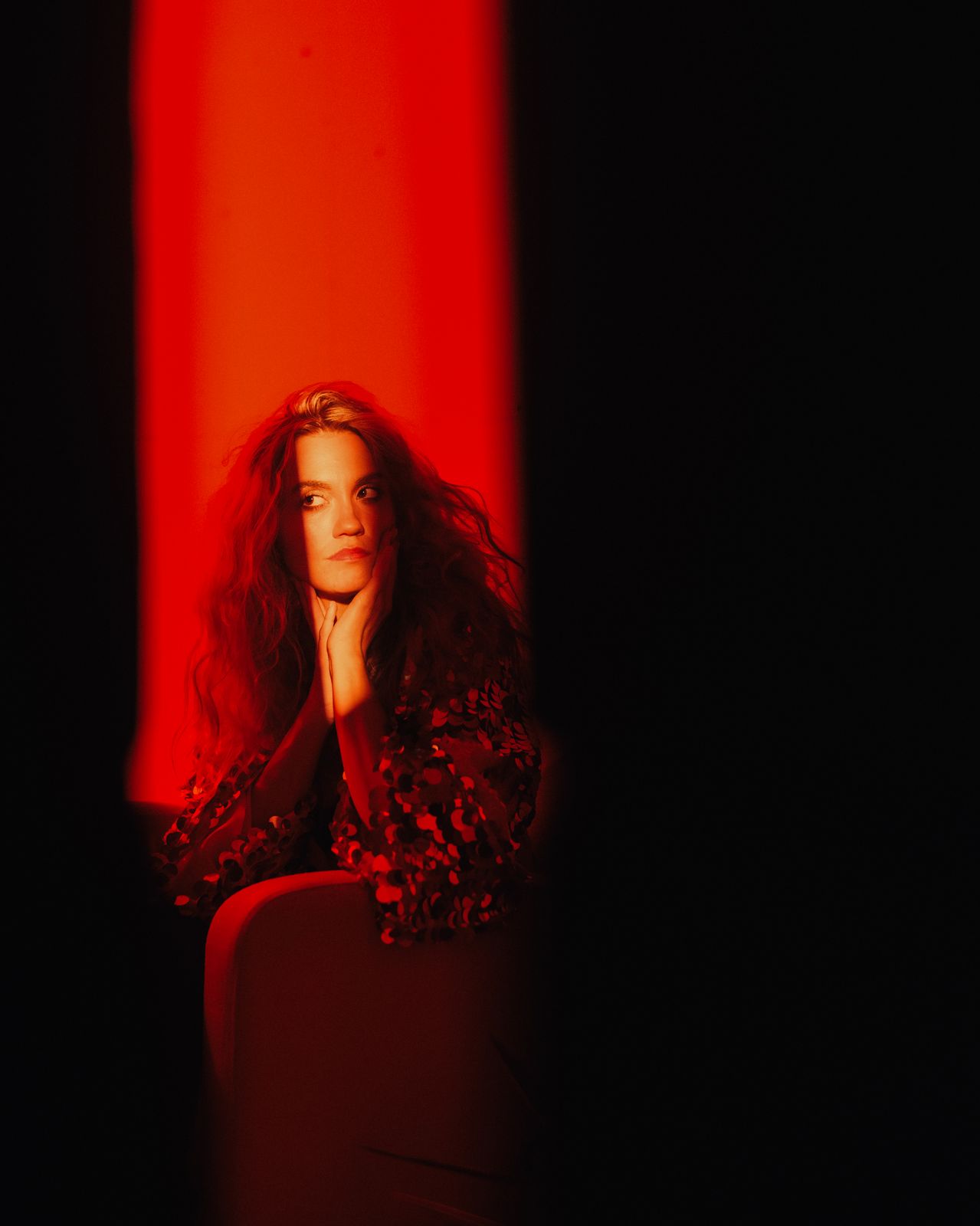 a woman sitting in a chair in a dark room