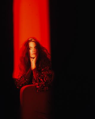 a woman sitting in a chair in a dark room