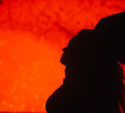 a silhouette of a person in front of a red background