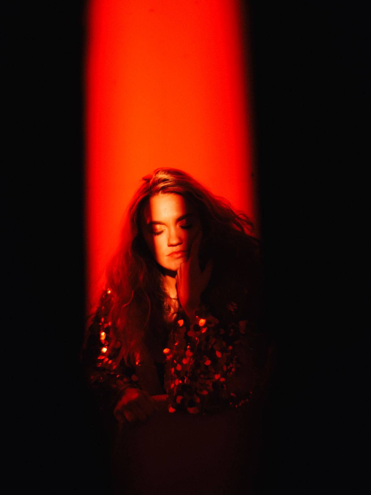 a woman standing in front of a red light