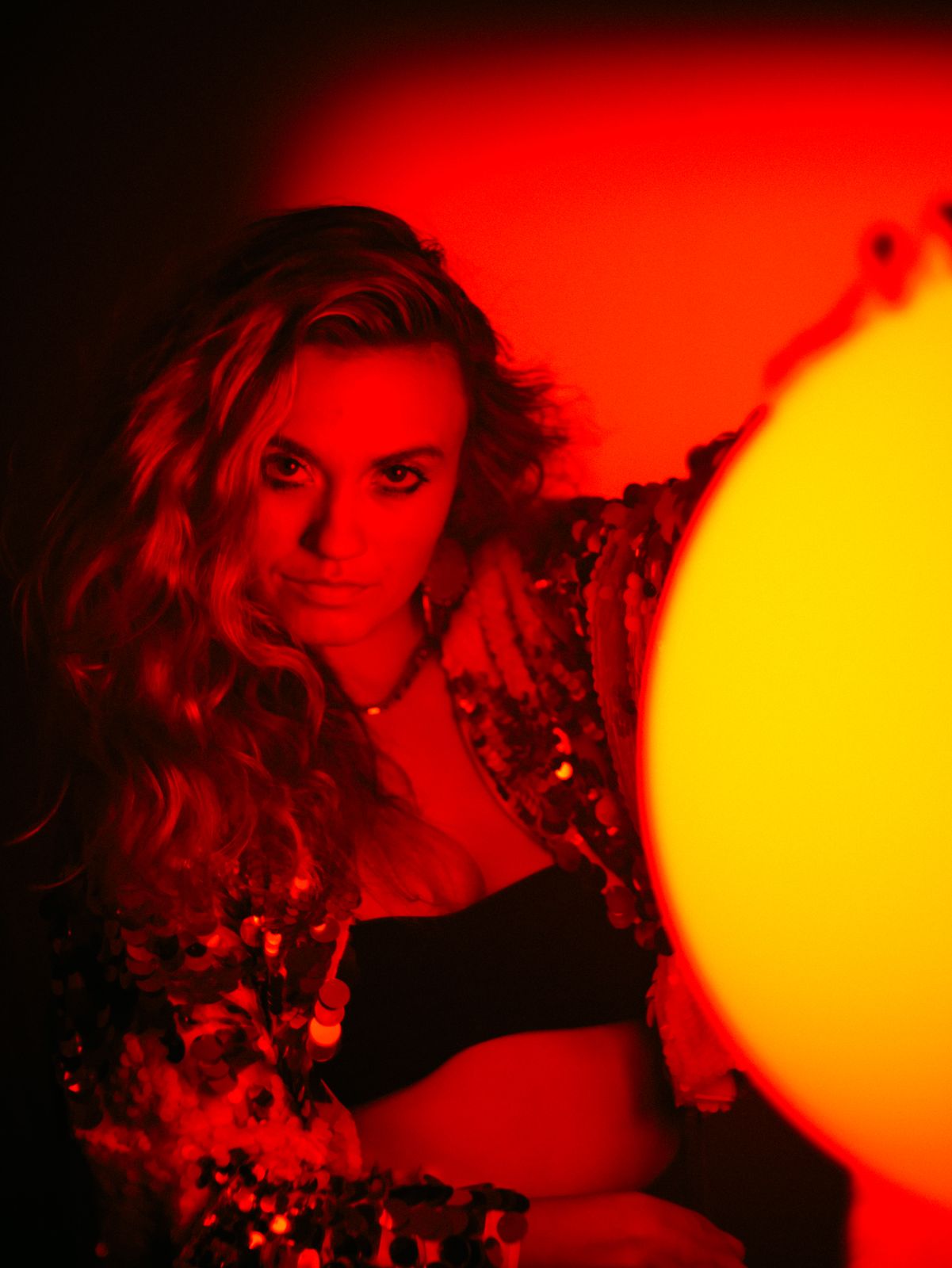 a woman in a dark room with a red light