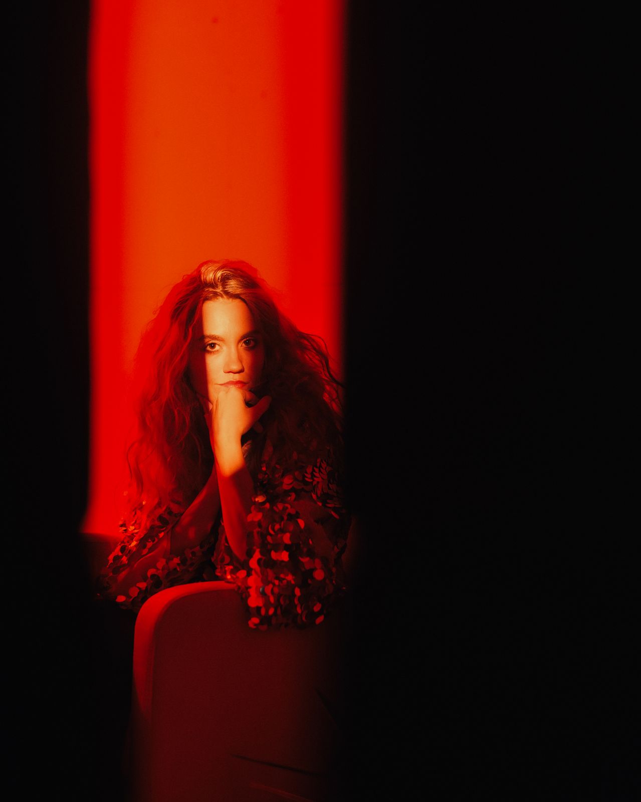 a woman sitting in a chair in a dark room