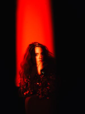 a woman sitting in front of a red light