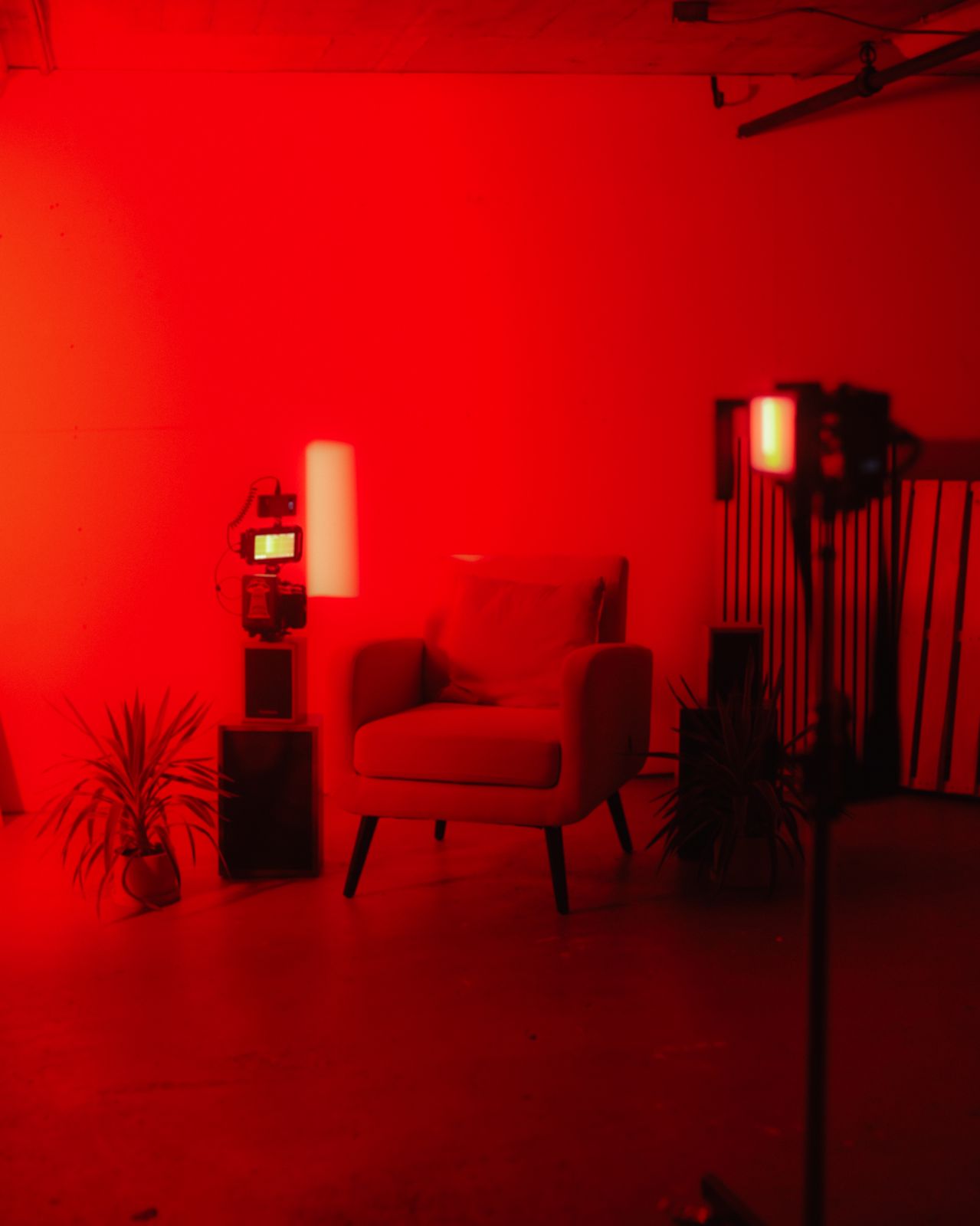 a red room with a chair and a lamp