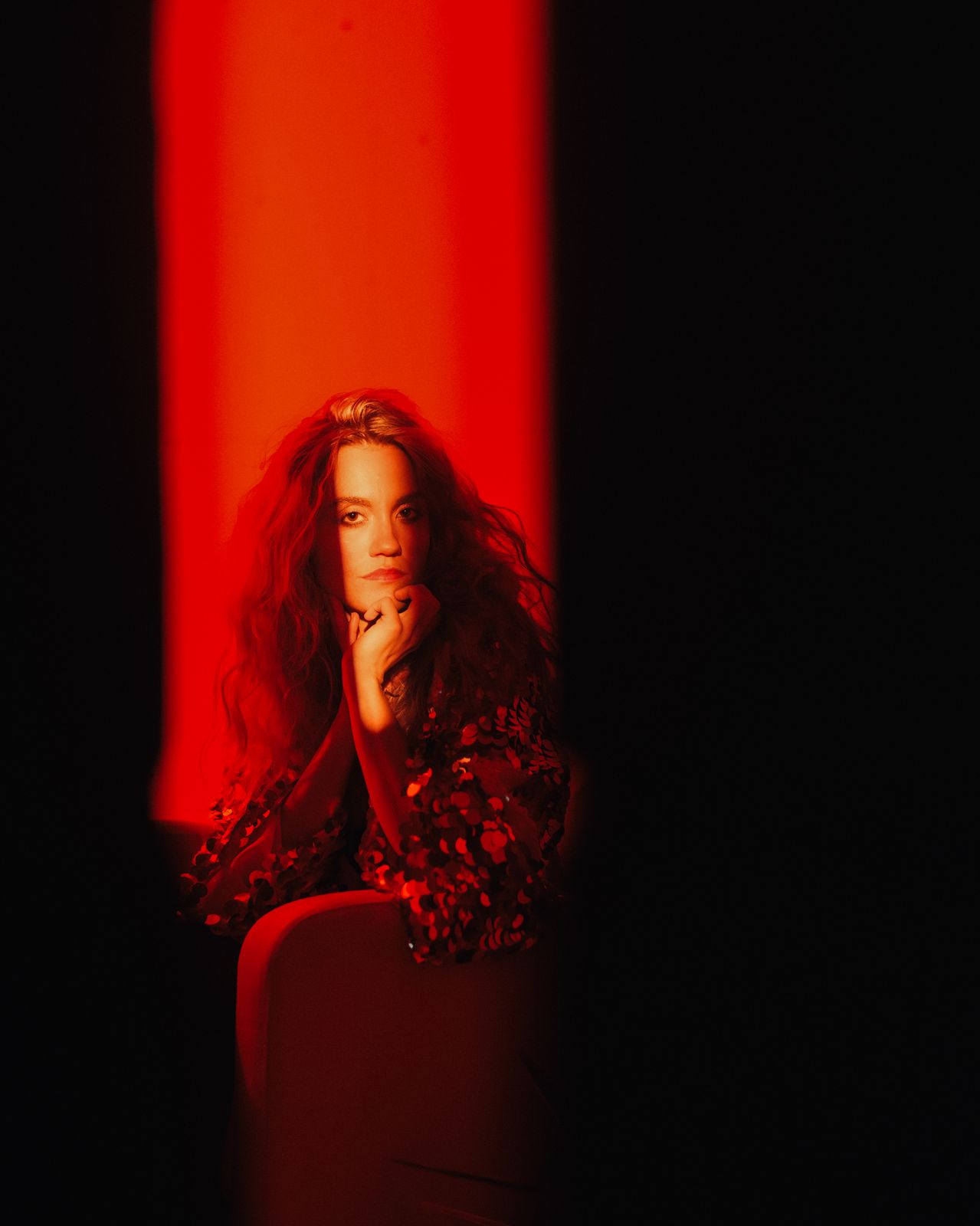 a woman sitting in a chair in a dark room