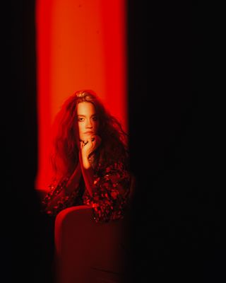 a woman sitting in a chair in a dark room