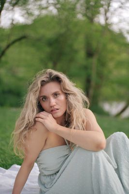 a woman in a dress sitting on a blanket