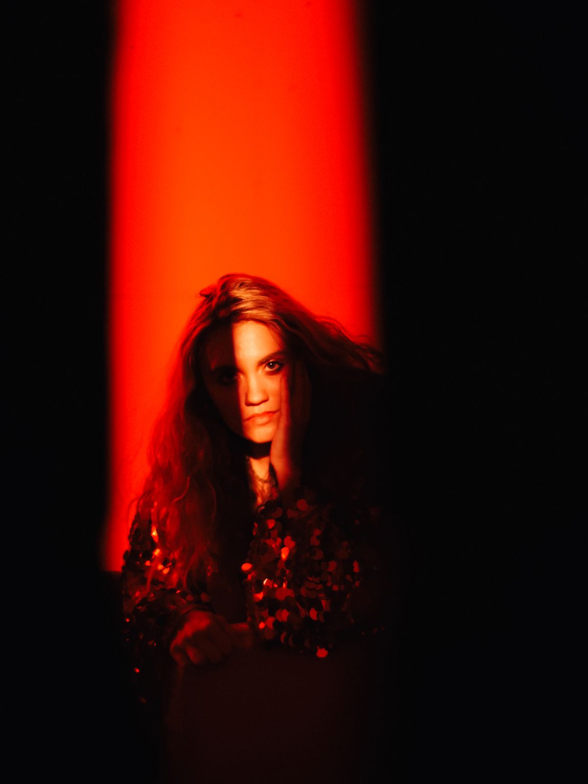 a woman standing in front of a red light