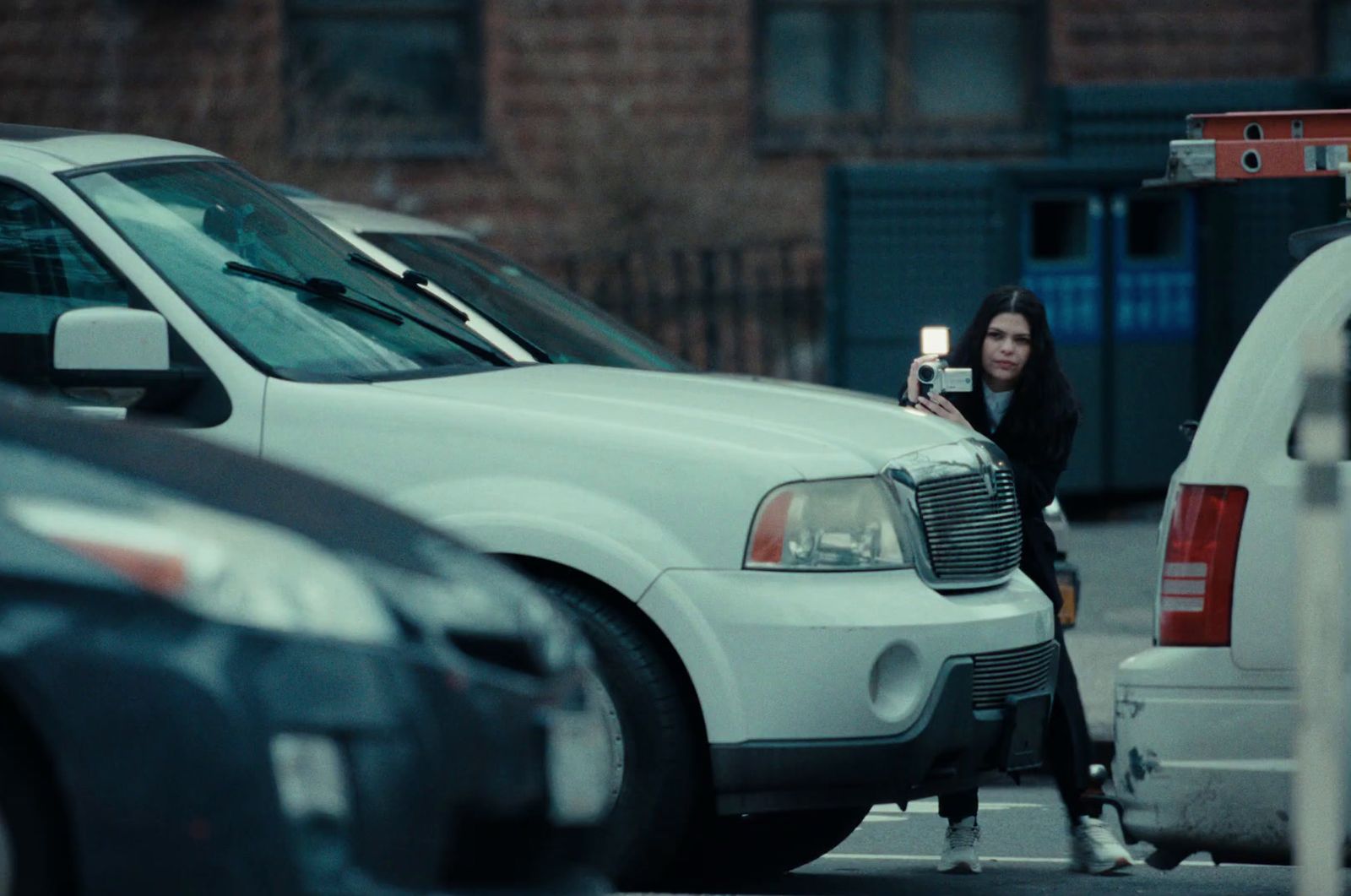 a woman taking a picture of a parked car