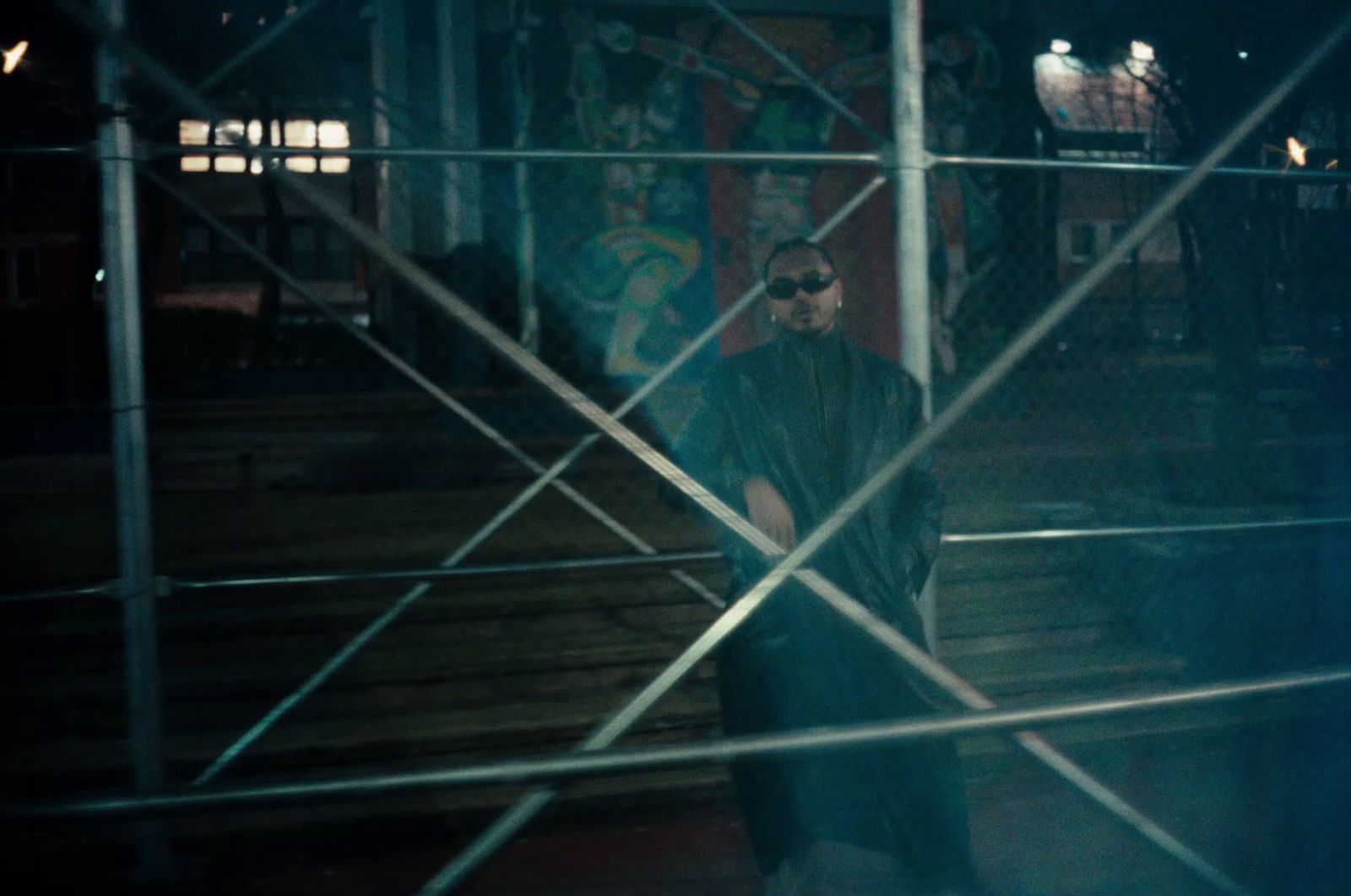 a man standing in front of a metal fence