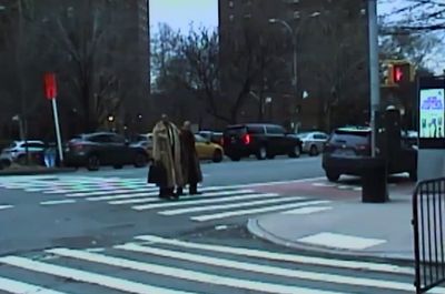 a man in a robe is crossing the street