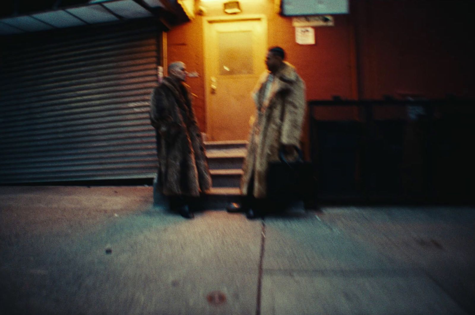 a couple of men standing next to each other on a sidewalk