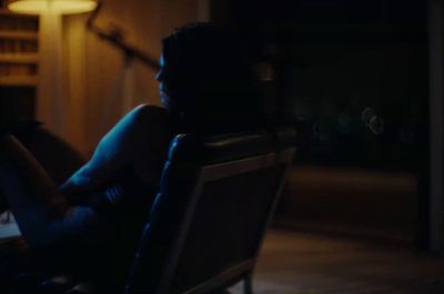 a woman sitting in a chair in a dark room