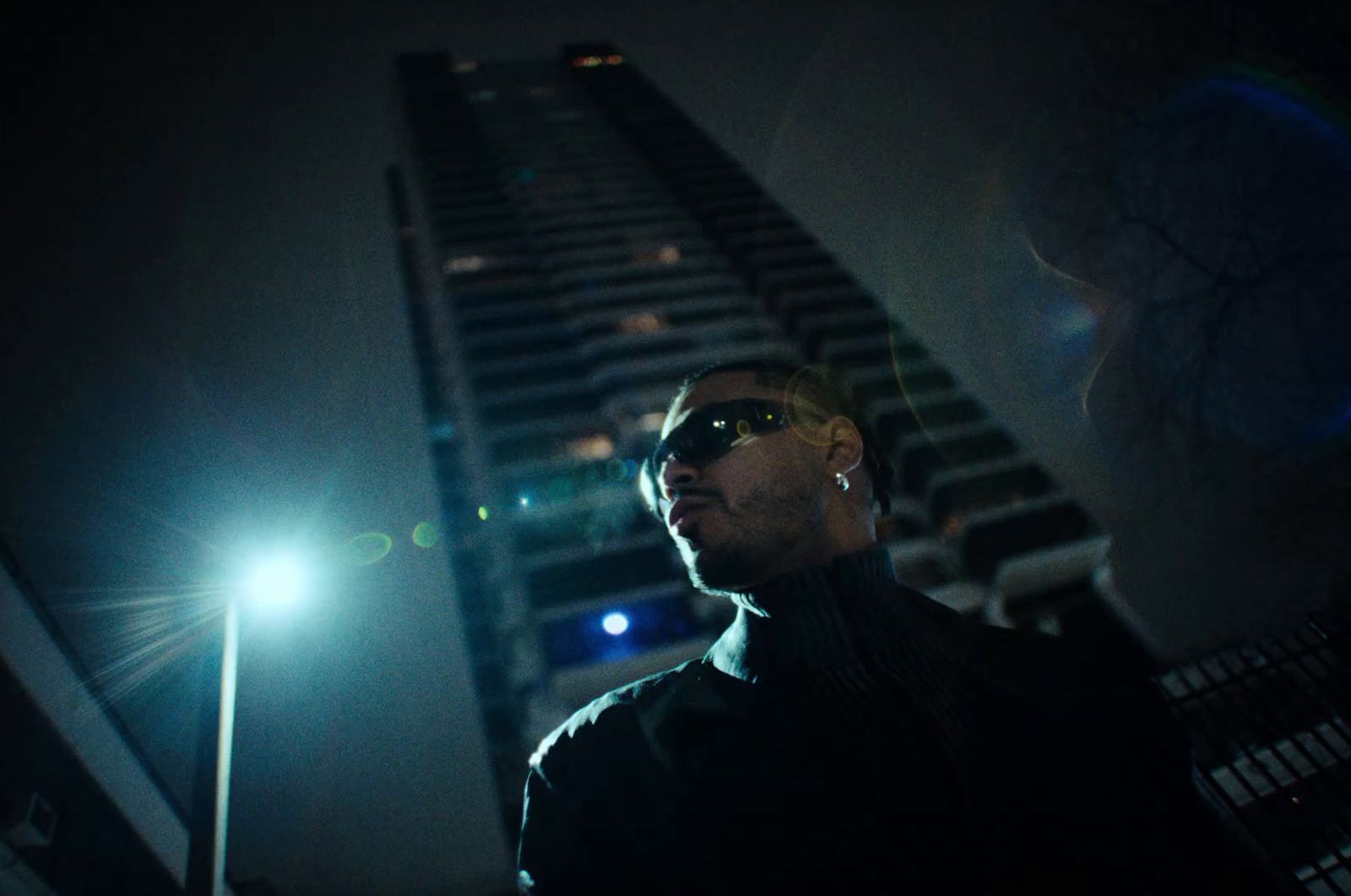 a man standing in front of a tall building at night