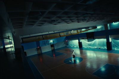 a person standing on a basketball court at night