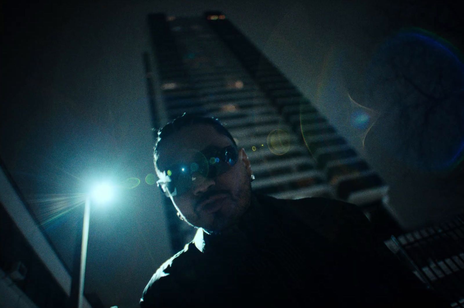 a man standing in front of a tall building at night