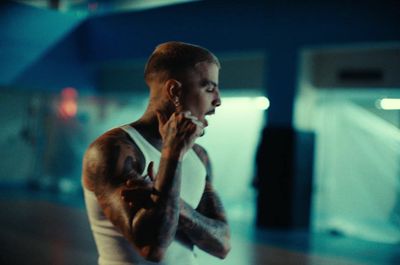 a man with tattoos smoking a cigarette