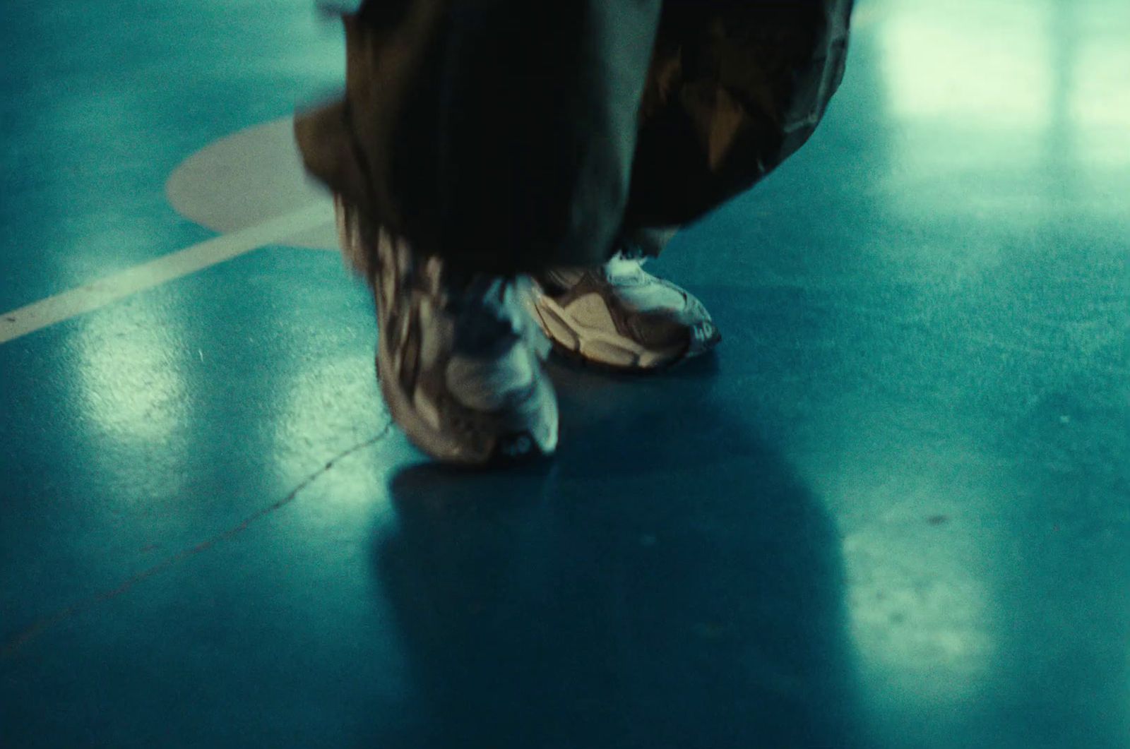 a person standing on a blue floor with a pair of shoes