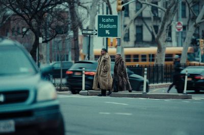 a man walking down a street next to a traffic light