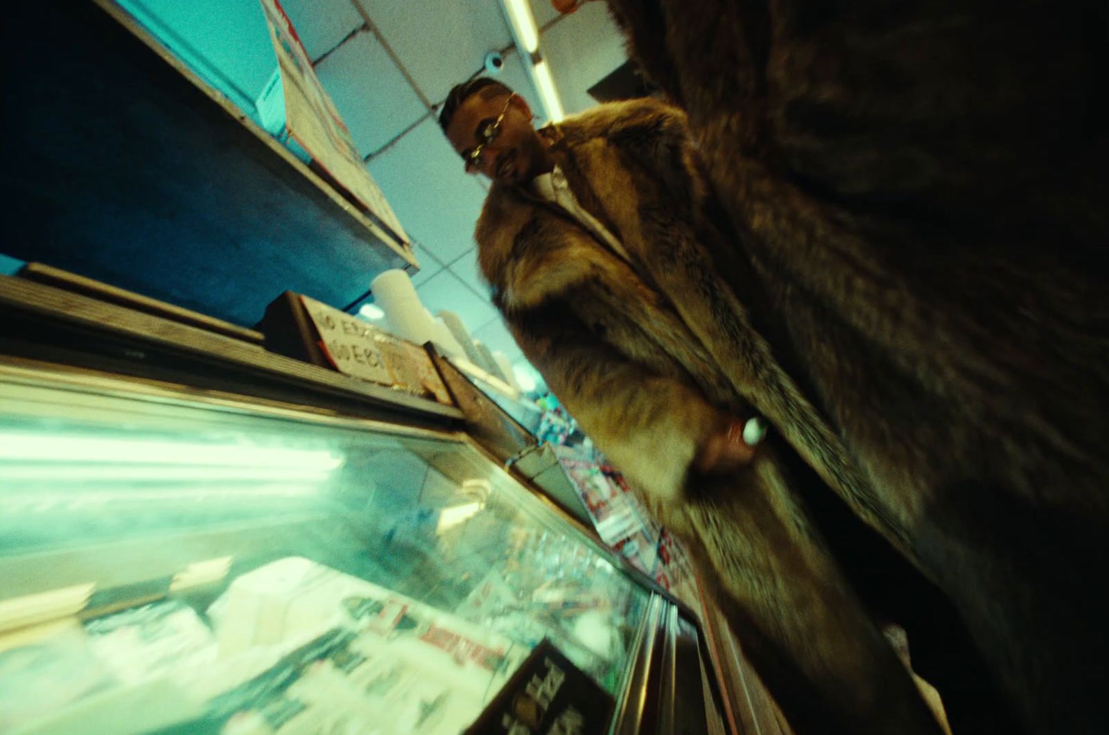 a man in a fur coat standing next to a store window