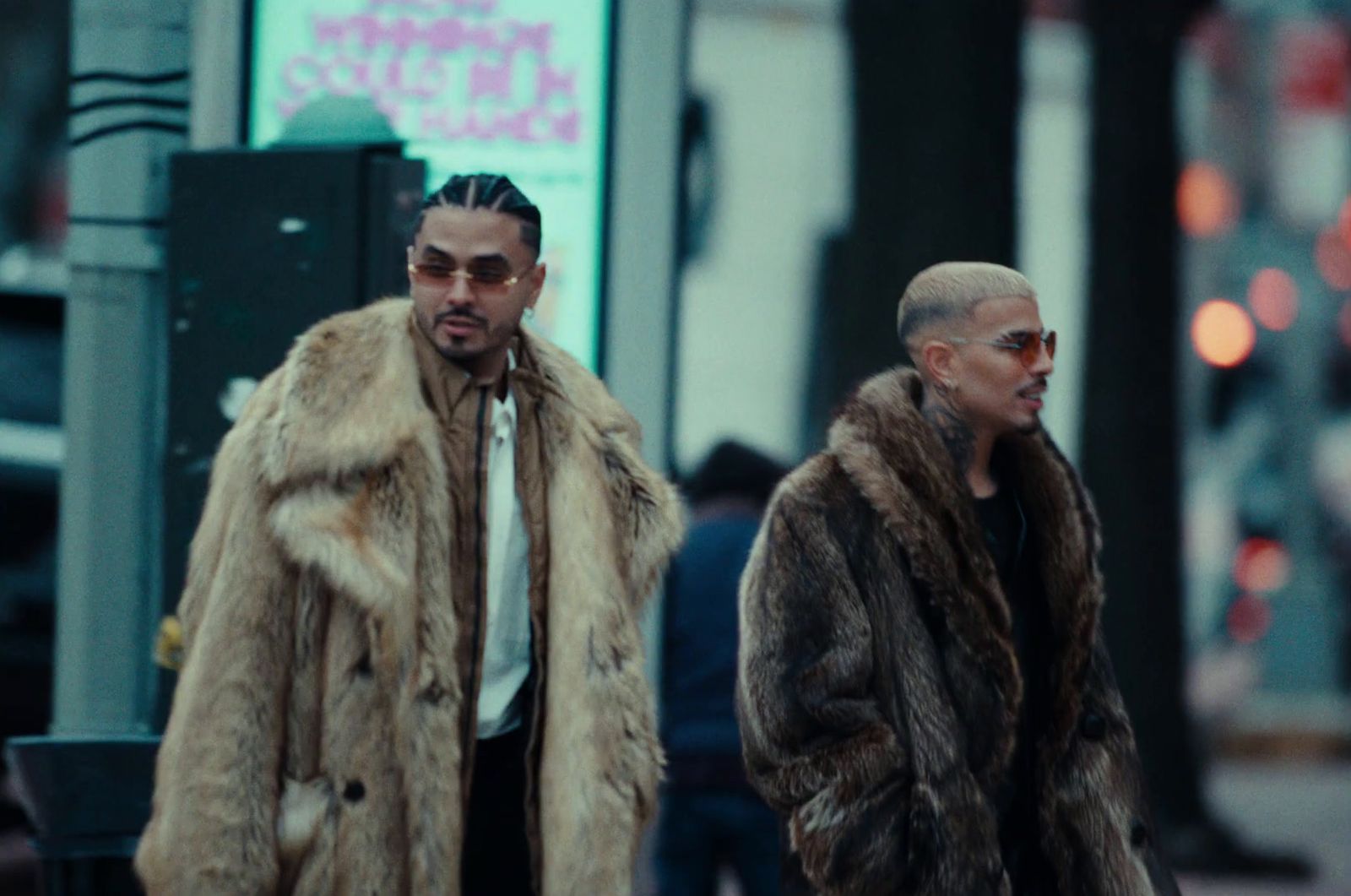 two men in fur coats walking down a street