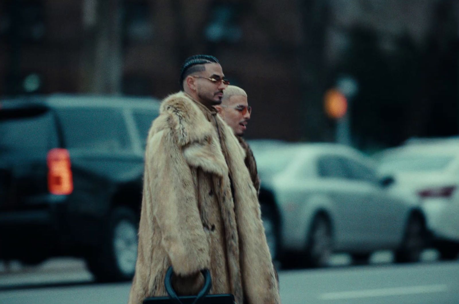 two men in fur coats walking down the street