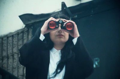 a woman looking through a pair of binoculars