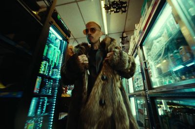 a man in a fur coat standing in a store